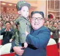  ??  ?? North Korea’s Kim Jong Un holding a child dressed in a military uniform — a look Kim favoured as a boy.