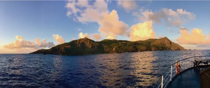  ?? /PHOTO COURTESY HACHETTE BOOK GROUP ?? REMOTE LAND: Pitcairn Island lies silhouette­d against the sky as a boat approaches in ‘The Far Land.’