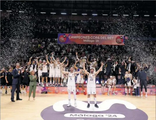  ?? ?? Sergio Llull y Ruy Fernández levantan el trofeo de campeones de Copa, el 29º del Real Madrid, en el centro de la pista del Martín Carpena.