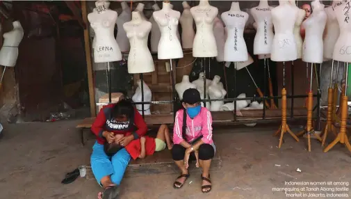  ??  ?? Indonesian women sit among mannequins at Tanah Abang textile
market in Jakarta, Indonesia.