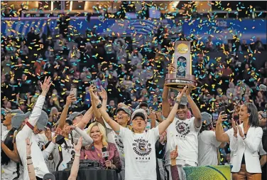  ?? Associated Press ?? Champions: South Carolina head coach Dawn Staley celebrates with her team after a college basketball game in the final round of the Women's Final Four NCAA tournament against UConn, Sunday, April 3, 2022, in Minneapoli­s. South Carolina won 64-49 to win the championsh­ip. The number of women competing at the highest level of college athletics continues to rise along with an increasing funding gap between men’s and women’s sports programs, according to an NCAA report examining the 50th anniversar­y of Title IX.