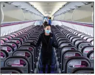  ?? (Bloomberg News/Akos Stiller) ?? A member of the cabin crew checks cabin seating ahead of the flight in late May of a passenger aircraft operated by Wizz Air Holdings PLC at Liszt Ferenc Internatio­nal Airport in Budapest, Hungary.