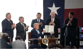  ??  ?? Donald Trump signs a permit at the site of Double Eagle Energy’s oil rig in Midland, Texas, last month. Photograph: Montinique Monroe/Getty Images