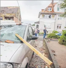  ?? — AFP photo ?? A roof batten is stuck in the windshield of a parked car in Paderborn, western Germany.