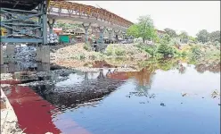  ?? RISHIKESH CHOUDHARY/HT ?? Waldhuni river water, flowing below Ramayan Nagar bridge in Ulhasnagar, turned red due to discharge of industrial effluents, on Wednesday.