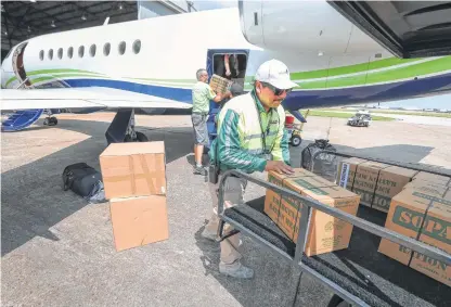  ?? Steve Gonzales / Houston Chronicle ?? MillionAir employee Manny Estrada unloads supplies for storm victims from Tracy and Laurie Krohn’s private plane.