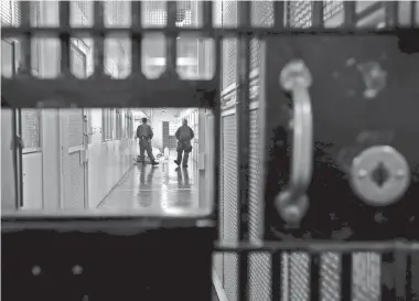  ?? BEN MARGOT/AP ?? Guards walk a corridor at San Quentin State Prison in San Quentin, Calif.