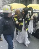  ?? GINA CHERELUS / REUTERS ?? Chaplain Ann Kansfield assists Nesh Pillay after a crane collapsed near the salon where she was having her hair done.