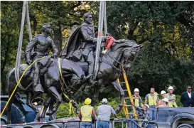  ?? Nathan Hunsinger / Dallas Morning News ?? Workers harness the Robert E. Lee statue to its trailer for its removal Thursday at Robert E. Lee Park in Dallas.