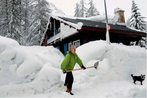  ?? — AFP ?? A woman shovels snow in the village of Val d’Isere as the precaution­s are put into place for motorists due to an avalanche alert in the French Alpes on Tuesday.