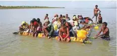  ?? Reuters ?? Rohingya refugees sail towards the bank of Naf River on a makeshift raft after crossing the Bangladesh-Myanmar border.