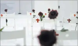  ??  ?? A memorial for the victims of the First Baptist Church of Sutherland Springs shooting includes 26 white chairs, each painted with a cross and bearing a rose.