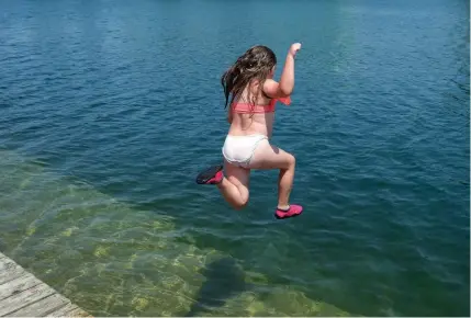  ?? DAVE JOHNSON
TORSTAR ?? Courtney Cowell jumps in the water at the Lincoln Street Docks in Welland to beat Wednesday’s sweltering heat.