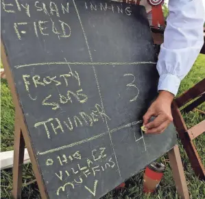  ??  ?? Travis Clark of Baltimore, Ohio, keeps score during a game between the Ohio Village Muffins and the Frosty Sons of Thunder of Somerset, Pa.