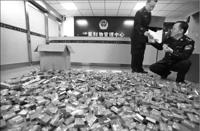  ?? BAO DONGSHENG / FOR CHINA DAILY ?? Police officers check confiscate­d condoms at an evidence center in Yuncheng, Shanxi province, on Wednesday. On Friday, the police caught two gangs making condoms illegally marketed as famous brands. A total of 1.24 million boxed condoms and 460,000...