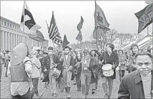  ?? David Fenton Getty Images ?? MEMBERS of the Youth Internatio­nal Party, or Yippies, march through Washington dressed as a Colonial-era fife and drum corps to protest Nixon’s inaugurati­on.