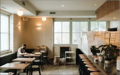  ?? (LYNDON FRENCH/THE NEW YORK TIMES) ?? The dining room of Kasama in Chicago with takeout boxes lining the bar on June 26, 2021. As in-person dining returns, home delivery is holding up.