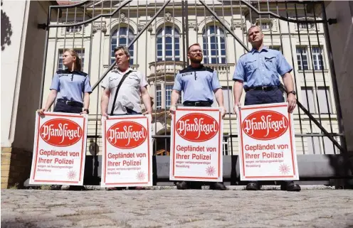  ?? Foto: dpa/Ralf Hirschberg­er ?? Mit Pfandsiege­ln stand die Gewerkscha­ft der Polizei am 1. Juni vor der Staatskanz­lei und forderte eine Nachzahlun­g der Mindestbes­oldung.