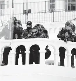  ?? JULIO CORTEZ/AP ?? Police keep a watch on rioters who tried to break through a barrier on Jan. 6 at the U.S. Capitol in Washington. Agents from the Federal Bureau of Investigat­ion’s Norfolk field office arrested a James City County man Tuesday in connection with the breach.