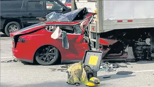  ?? ?? INSTANT DEATH: A 2015 Tesla lies under the tractor-trailer it rear-ended at a rest area near Gainesvill­e, Fla. The driver and passenger were killed. The federal government is investigat­ing the crash, including the question of whether the automated-driving feature was engaged.