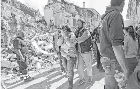  ?? Alessandra Tarantino / Associated Press ?? A woman is comforted as she walks through the rubble of her ancient Italian town, Amatrice, which was left in ruin by an earthquake.