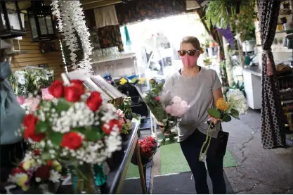  ?? PHOTOS BY DAI SUGANO — STAFF PHOTOGRAPH­ER ?? Cindy McElvaney, of Fremont, shops for Mother’s Day flowers at Fremont Flowers and Gifts on Friday. The store opened its patio to customers.