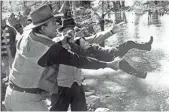  ?? JOHN R HAMILTON, JOHN WAYNE ENTERPRISE­S ?? Wayne plays at tossing Ethan, then 3, into the river on the set of Katie Elder.