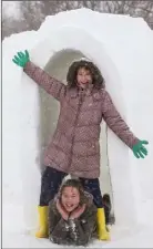  ??  ?? Kyra and Makenzie Molloy with the igloo they made in Foulksmill­s.