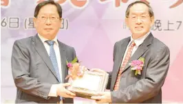  ??  ?? Yong (right) presenting a souvenir to Lau during the installati­on ceremony of the 19th United Associatio­n of Private Chinese Secondary School Committee Sabah.