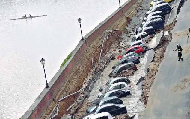  ??  ?? Sommerse Le auto in sosta sul Lungarno Torrigiani dove è avvenuto il crollo, vicino al Ponte Vecchio. La voragine è stata provocata dalla rottura di due tubature (Ansa/Maurizio Degl’Innocenti)