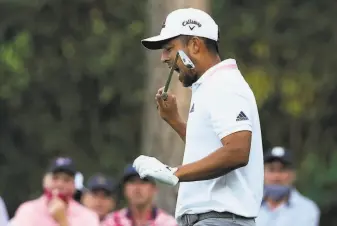  ?? Charlie Riedel / Associated Press ?? Xander Schauffele bites his club after his second tee shot on No. 16 during the final round of the Masters tournament in Augusta, Ga. His first tee shot went into the water.