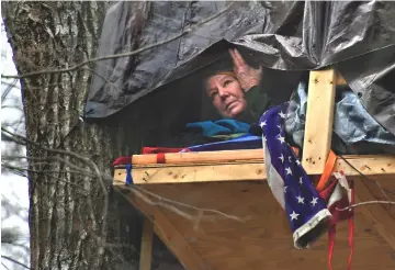  ??  ?? Theresa “Red” Terry has planted herself in a tree in Southwest Virginia to protest constructi­on of the Mountain Valley Pipeline.