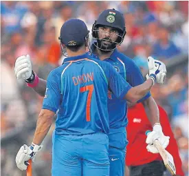  ??  ?? India’s Yuvraj Singh congratula­tes his teammate Mahendra Singh Dhoni.