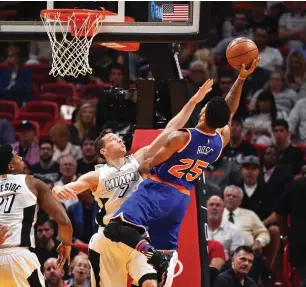  ?? (Reuters) ?? NEW YORK KNICKS guard Derrick Rose shoots over Miami Heat guard Goran Dragic for two of his 10 points in the Knicks’ 114-103 road defeat of the Heat on Tuesday night.