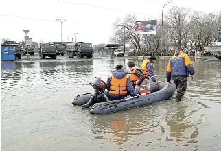  ?? /Reuters ?? Rising danger:
Rescuers on a dinghy in a flooded street in the Russian city of Orsk after the Ural River burst through dam embankment­s last week.