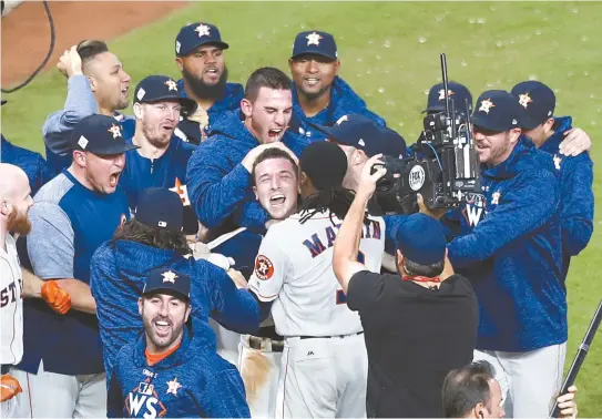  ?? EPA-Yonhap ?? Houston Astros batter Alex Bregman, center, is mobbed by teammates after driving in the game-winning run in the bottom of the 10th inning of the Major League Baseball (MLB) World Series game five against the Los Angeles Dodgers at Minute Maid Park in...