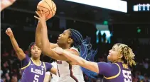  ?? NELL REDMOND/AP ?? South Carolina forward Aliyah Boston, center, is fouled as she shoots by LSU guard Kateri Poole (55) during the first half on Sunday.