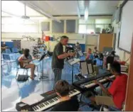  ??  ?? Dave Snediker, center, leads rehearsals of Rock Camp participan­ts, including, clockwise from upper left, Hunter Wittner, 11, Adam Clemens, 16, Peter Tolmei, 12, Logan Cuda, 11, Keerthi Martyn, 15, Noah Daley-Bruni, 11, and Elli Noti, 15, on July 28at...