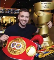  ??  ?? Champion: Taylor with his IBF and WBA world titles, and Muhammad Ali trophy