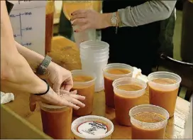  ?? RYON HORNE / RHORNE@AJC.COM PHOTOS ?? Volunteers prepare containers of soup at the Westside location of Souper Jenny for distributi­on to other nonprofit organizati­ons.