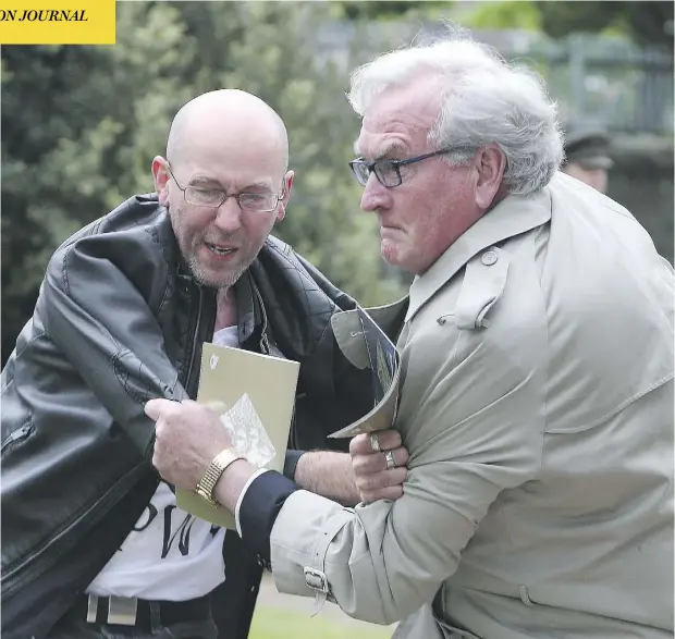  ?? BRIAN LAWLESS / PA VIA THE ASSOCIATED PRESS ?? Canadian Ambassador to Ireland Kevin Vickers, right, grapples with Brian Murphy, a protester who had begun to disrupt a ceremony
in remembranc­e of the British soldiers who died during the 1916 Easter Rising, at Grangegorm­an Military Cemetery in Dublin.