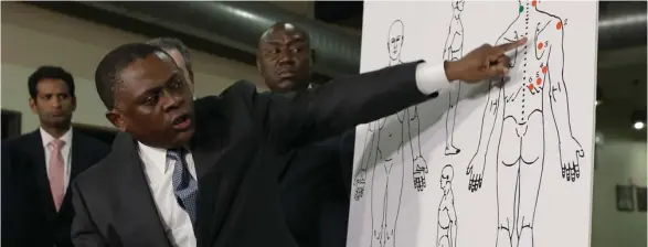  ?? Pedroncell­i, AP) (Photo by Rich ?? Pathologis­t Dr. Bennet Omalu points to details in a diagram showing the gunshot wounds he found on the body of Stephon Clark who was shot by Sacramento police, during a news conference Friday, March 30, 2018, in Sacramento, Calif. Omalu was hired by...