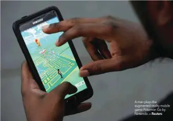  ?? — Reuters ?? A man plays the augmented reality mobile game Pokemon Go by Nintendo.