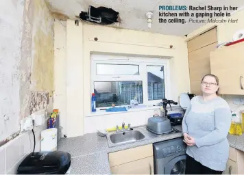  ??  ?? PROBLEMS: Rachel Sharp in her kitchen with a gaping hole in the ceiling.