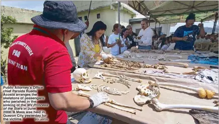  ?? BOY SANTOS ?? Public Attorney’s Office chief Persida Rueda Acosta arranges the skeletons of passengers who perished in the sinking of the MV Princess of the Stars in June 2008. A Mass was held in Quezon City yesterday for the victims.