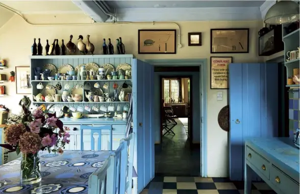  ??  ?? Clockwise from above left The sitting room’s linen curtains were hand-painted by Annabel Grey, who also created the floral oilcloth in the kitchen; the homeowner, bookseller Simon Finch