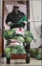  ?? THE MORNING JOURNAL FILE ?? Clarence Ballard, then 77, of Lorain unloads sacks of cabbage in the kitchen of Greater Victory Christian Ministries Church in 2017.