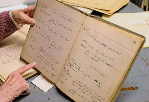  ?? ?? In Fort Edward, Loretta Bates, deputy historian for Washington County, looks through record books from the county’s poorhouse. Bates is the author of the book, “Those Called Paupers,” about children who went through the poorhouse.