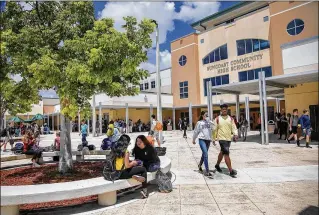  ?? PHOTOS BY BILL INGRAM / THE PALM BEACH POST ?? Suncoast High School students sit and walk in the Riviera Beach school’s courtyard last month. Suncoast is one of seven county schools with just one lunch hour.