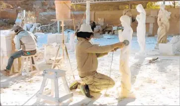  ?? Xu Wang and Equitable Vitrines ?? ARTIST XU WANG works on a statue of Eve, which he gave a Chinese face. An arts nonprofit spurred discussion in Monterey Park with its proposal to temporaril­y place this work beside the city’s statue of Athena.